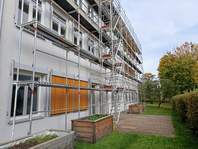 Layher Fassadengerüst mit Treppenturm – Wohnblock-Sanierung — Gerüste — gebraucht mieten | 123Machinery