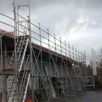 Layher Fassadengerüst mit Treppenturm – Industriehallen — Gerüste — gebraucht mieten | 123Machinery
